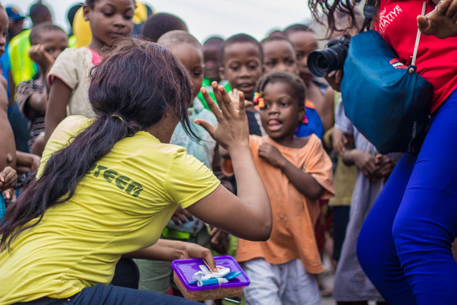 A community volunteer engaging with children during an outreach activity